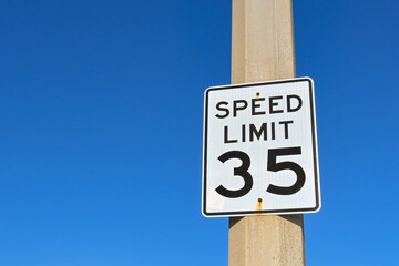 Speed limit sign in the USA isolated against a deep blue sky. No people. Copy space, - obrazy, fototapety, plakaty