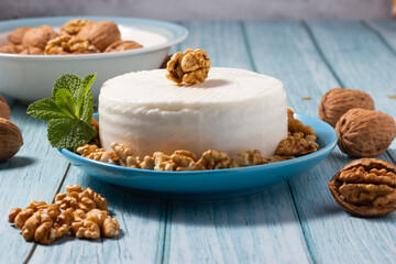 Set of fresh goat cheese and walnuts decorated with mint leaf. Mediterranean cuisine. Healthy cooking concept.