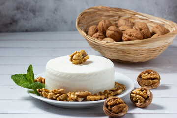 Piece of fresh goat cheese with walnuts. healthy food. Mediterranean cuisine.