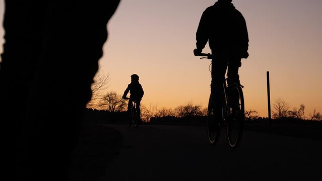 Zwei Jungs fahren mit dem Fahrrad an einem sch&ouml;nen Sommerabend in Richtung Horizont