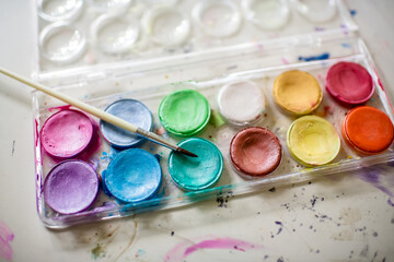 Watercolor paints on painted desk