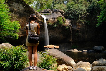 A young woman visiting Haew Suwat Waterfall, a natural beauty in a large forest