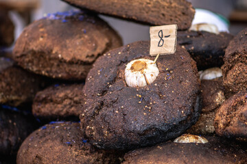 Homemade black rye cereal bread with garlic and seeds in a traditional street food market, close up