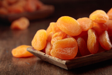 Dried apricots in a wooden dish.
