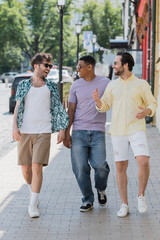 Overjoyed multiethnic friends walking on Andrews descent in Kyiv.