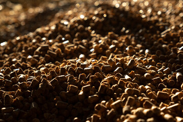 Pine pellets for farm horse stall bedding as background.