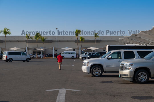 Licenciado Gustavo Díaz Ordaz International Airport building along with cars, SUVs and passenger vehicles picking up and dropping off travelers. 