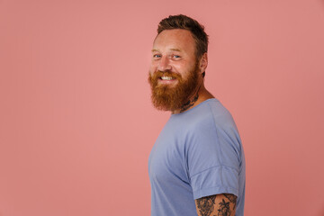 Portrait of adult bearded tattooed handsome stylish smiling man