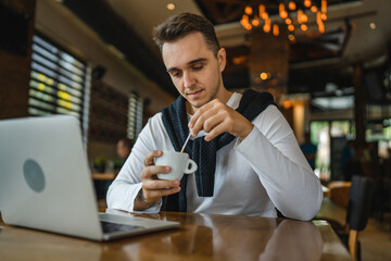 one man work on the computer laptop while sit at cafe or restaurant