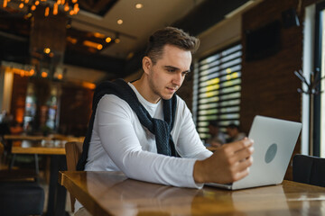 Fototapeta premium one man work on the computer laptop while sit at cafe or restaurant