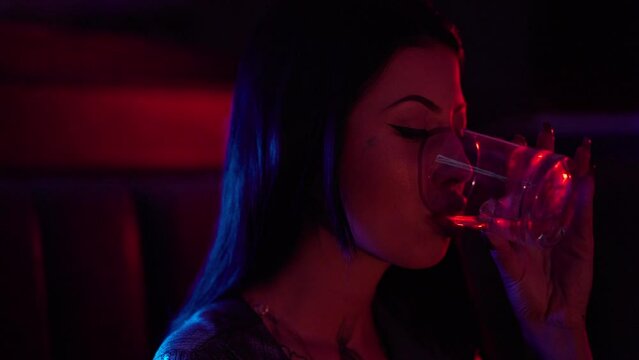 Party commercial video. Beautiful sexy female in club with red and blue lights dancing to music