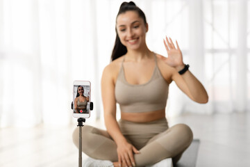 Fototapeta na wymiar Selective focus on cell phone recording female fitness coach
