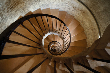 Ancient castle tower interior with spiral staircase leading down - 580771468