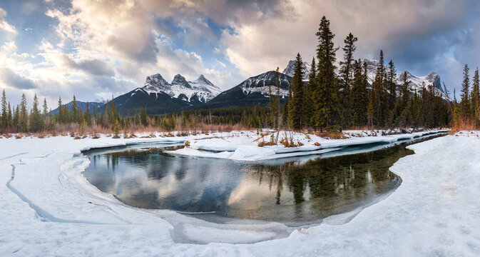Panorama view of Three Sisters Mountains with snow covered on bow river reflection in the morning on winter at Canmore