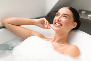 Obraz na płótnie Canvas Attractive Female Taking Bath With Foam In Modern Bathroom