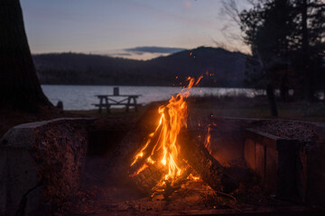 A campfire with a couple of embers on a lake