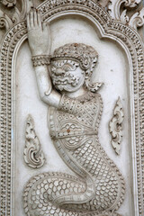 Fototapeta na wymiar Wat Mahathat, Phetchaburi. Relief depicting a yakkha (head) on a snake body. Thailand.