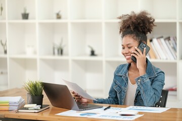 Obraz premium Smart African women working in beautiful office, working on Laptop, use the phone, talking on the cellphone. 
