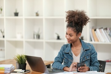 Smart African women working in beautiful office, working on Laptop, use the phone, talking on the cellphone. 