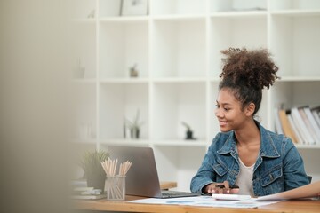 Smart African women working in beautiful office, working on Laptop, use the phone, talking on the cellphone. 