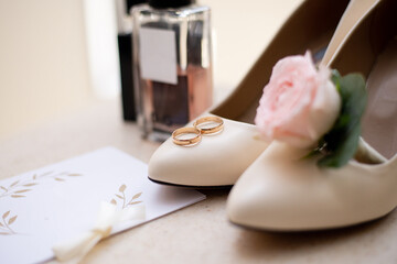 wedding rings and shoes on the background of a bouquet. idea for event agencies