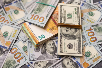 200 Euro banknote next to 50 euros on top of one hundred dollar bills. Trading Euro with Dollar