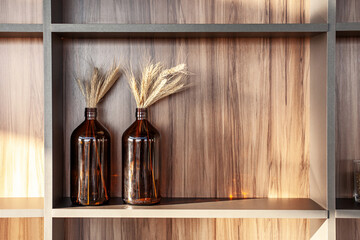 Wooden shelf decorated with bottles and wheat.