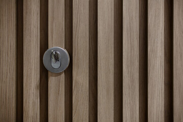 Decorative wooden slatted door lock.
