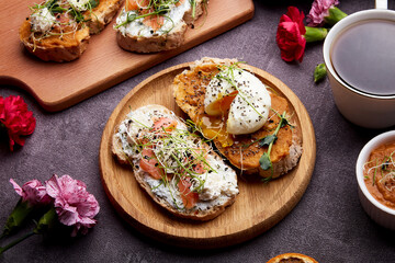 Sandwiches with greens, poached egg, salmon, spread, zucchini sauce, coffee cup - aesthetic breakfast. FODMAP diet, low in calories, healthy superfood