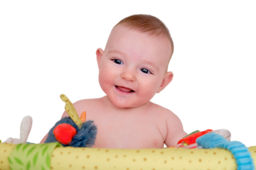 Happy infant baby plays in bed with hanging toys, mobile above the crib. Kid aged six months