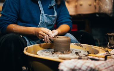Obraz na płótnie Canvas Craftsman potter making jug of clay on the potter's wheel circle in workshop