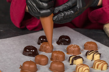 A confectioner decorates sweets with the help of a confectioner's bag