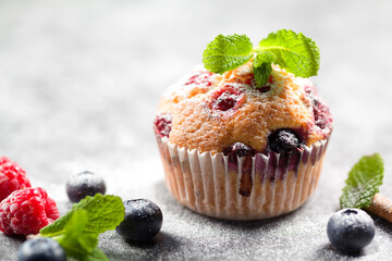 Freshly baked muffins with powdered sugar and fresh berries