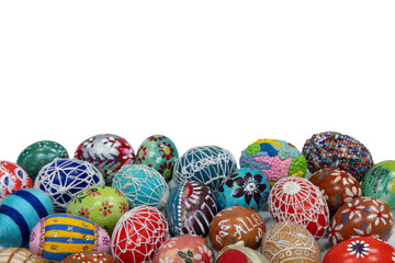 Many different colored Easter eggs lie side by side on a white background.
