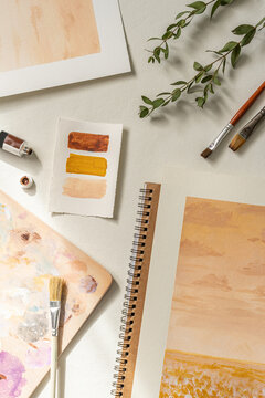 Aesthetic art flatlay with painting and tools, summer sunlight, warm neutral palette