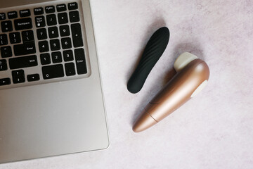 Vibrator with laptop flat lay. Sex shop online. Virtual chatting