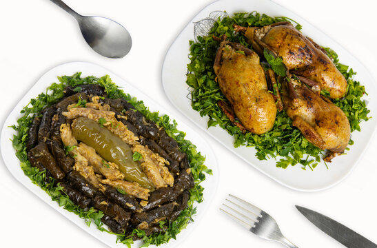 Traditional Egyptian Cuisine: Stuffed Pigeon (Hamam Mahshi) and Vegetarian Stuffed Cabbage, Peppers, and Vine Leaves on white background