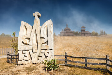 Ukrainian symbol. Coat of arms of Ukraine carved out of stone against a yellow-blue background,...