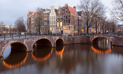 Fototapeta na wymiar Beautiful old houses on the city embankment of Amsterdam at sunset.