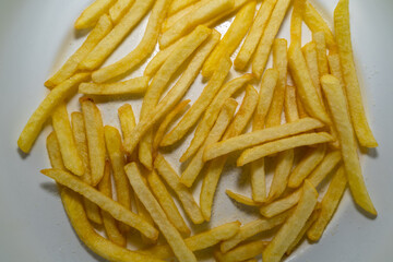 Fried and salted fries on a white plate