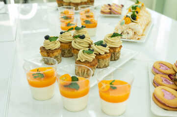 Candy bar for the holiday with muffin and cream, tangerine panna kota , desserts on the table