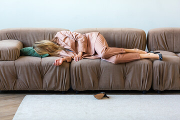 A mentally burned out businesswoman lies on a sofa.