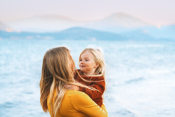 Child daughter and mother family vacations lifestyle travel together mom hugging kid walking...