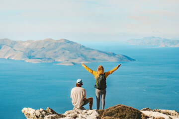 Couple travelers hiking in Greece together outdoor travel lifestyle active summer vacations man and woman on Akramitis mountain top enjoying aerial sea view explore Rhodes island - obrazy, fototapety, plakaty