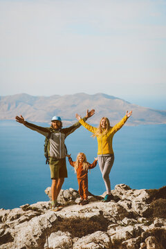 Family hiking in Greece parents with child travel outdoor mother and father raised hands active summer vacations healthy lifestyle eco tourism in Rhodes island mountain top