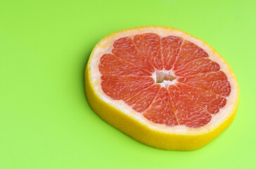 Fresh red grapefruit on a green background. Tropical fruit.
