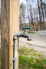 Clean water tap attached to a wooden post at a campground