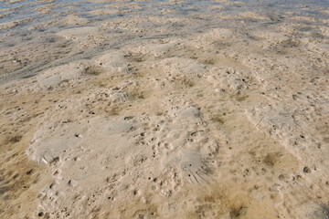 Sun shines to shallow sea during low tide, wet sand visible