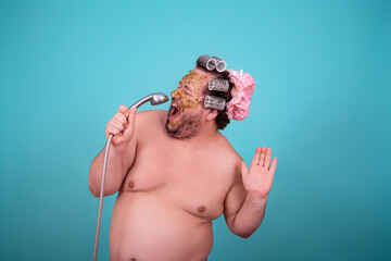 Beauty and skin care. Funny fat man washes in the shower in a cosmetic mask.