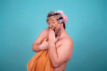 Beauty and skin care. Funny fat man washes in the shower in a cosmetic mask.